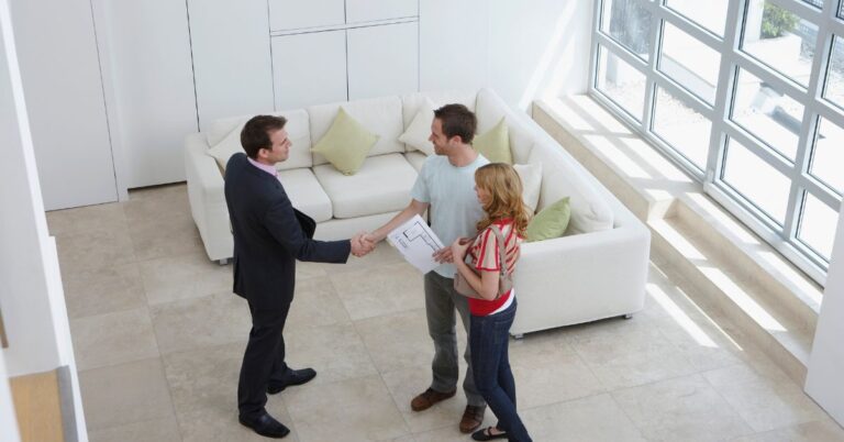 Agent za prodaju nekretnina i kupci u stanu se rukuju